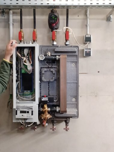 Wärmeübergabestation: statt der Heizung hängt in einem Gebäude ein solcher Kasten