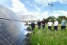 Personengruppe steht vor einer Photovoltaikanlage
