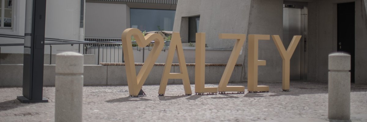 Man sieht große, goldfarbene Buchstaben mit einem Herz vor dem Wort „ALZEY“ auf dem Museumsplatz vor dem Museum. Das Herz steht für Verbundenheit mit der Stadt und der Ort dient als Fotopunkt für Besucher.
