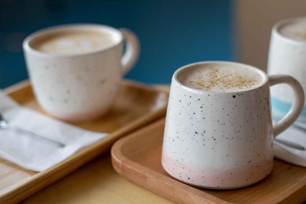 Man sieht mehrere Tassen gefüllt mit Kaffee.
