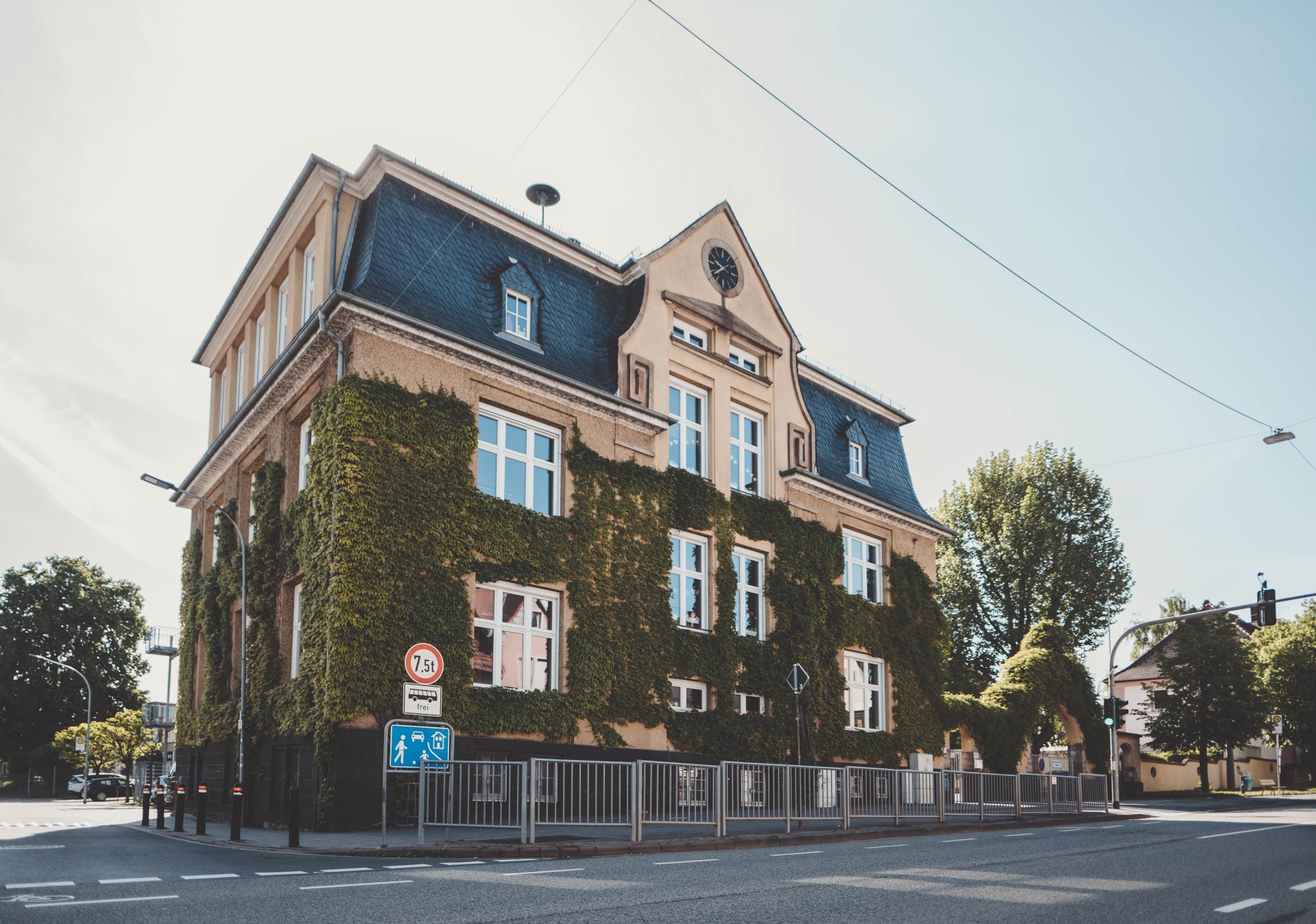 Grundschule Nibelungenschule eine mit grünen Blättern voll gewachsene Schule von Außen