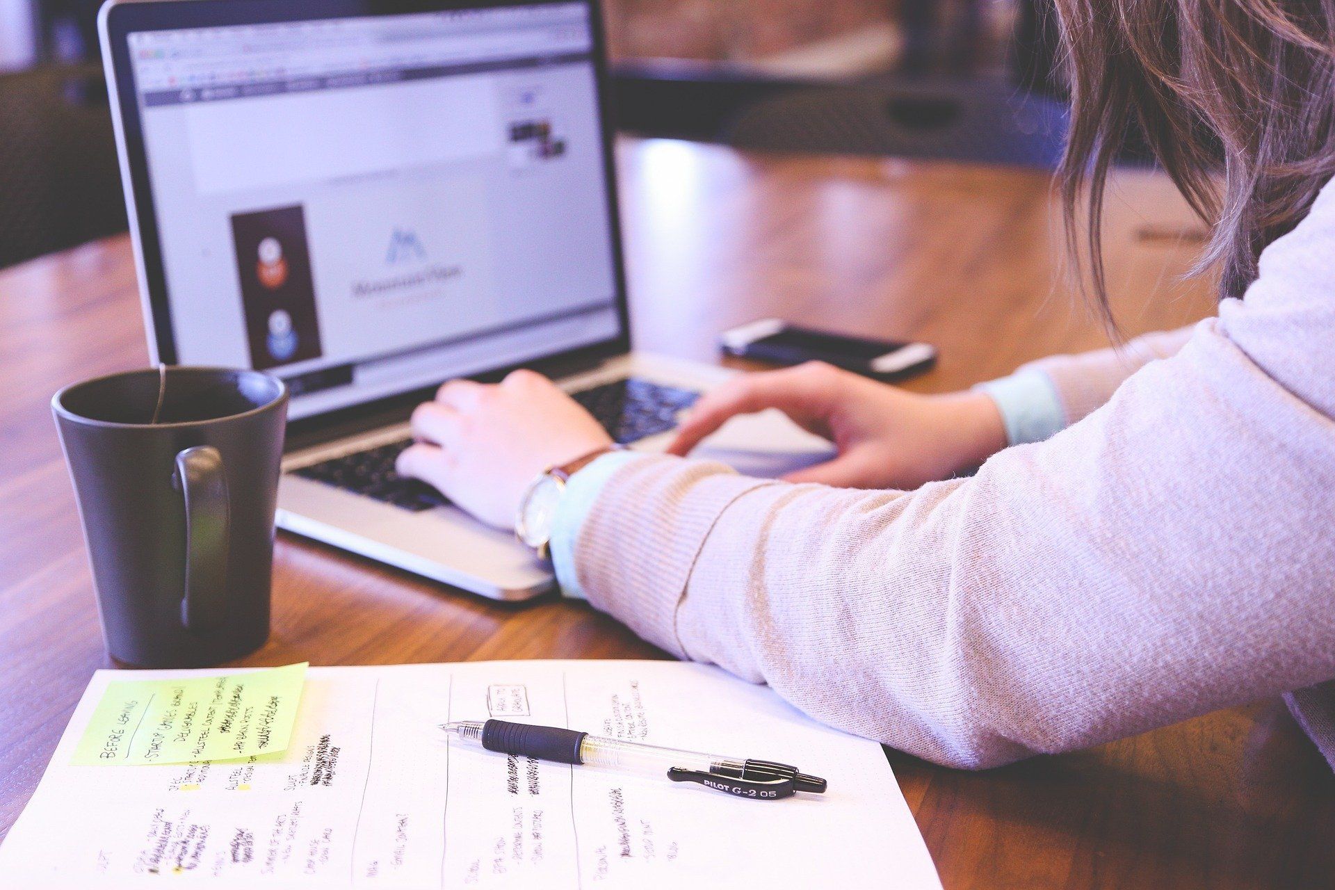 Person schreibt mit ihrem Laptop