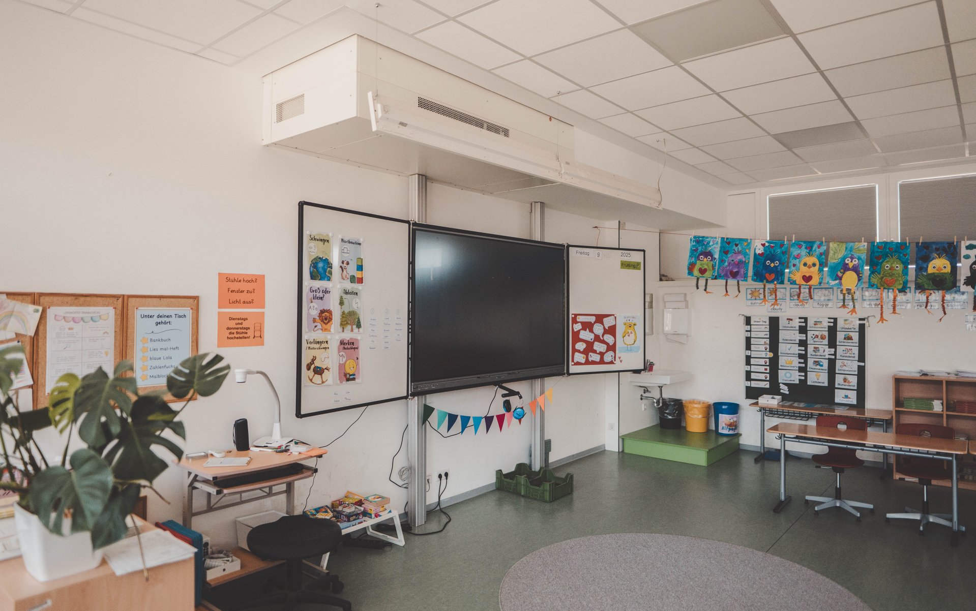 Eine digitale Tafel in einem bunt eingerichteten Klassenraum.