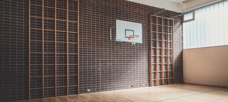 Sporthalle mit hölzernen Kletterwänden.