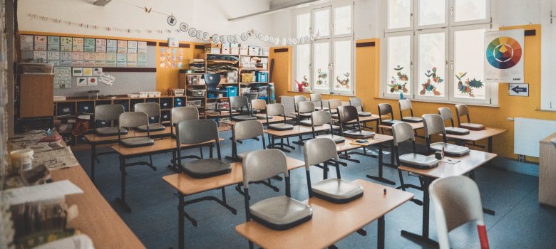 Klassenzimmer, auf dem die Stühle auf die Tische gestellt wurden.