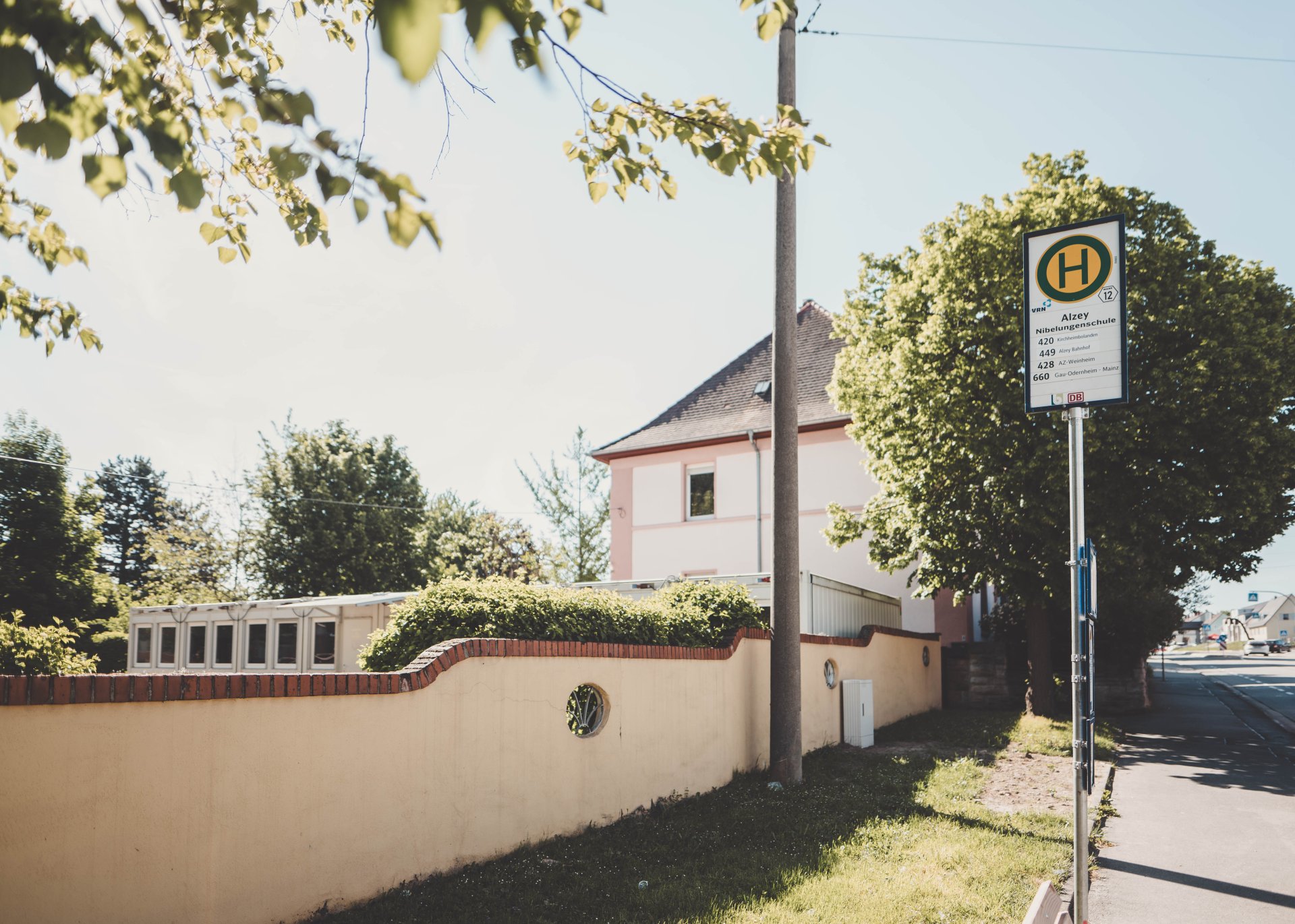 Bushaltestelle vor der Mauer des Schulhofes des Nibelungenschule.