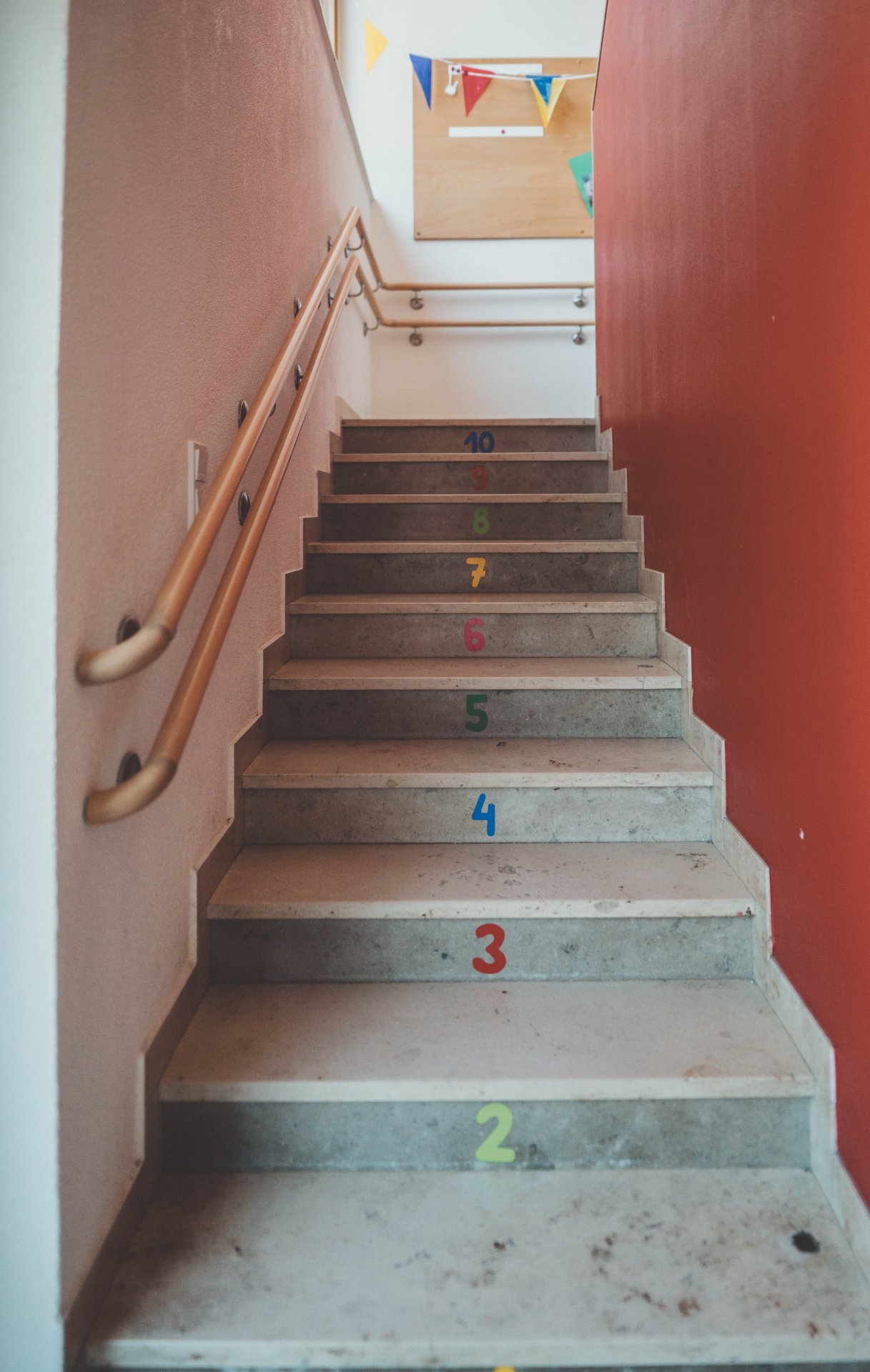 Kita Am Sonnenberg Beschriftete Treppen mit den Zahlen eins bis zehn in bunt.