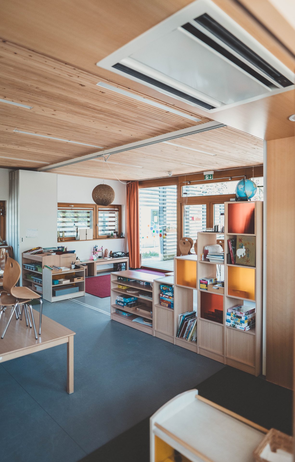 Kita Hanni Kipp Eine räumliche Abtrennung in einem Klassenraum durch Bücherregale aus Holz.