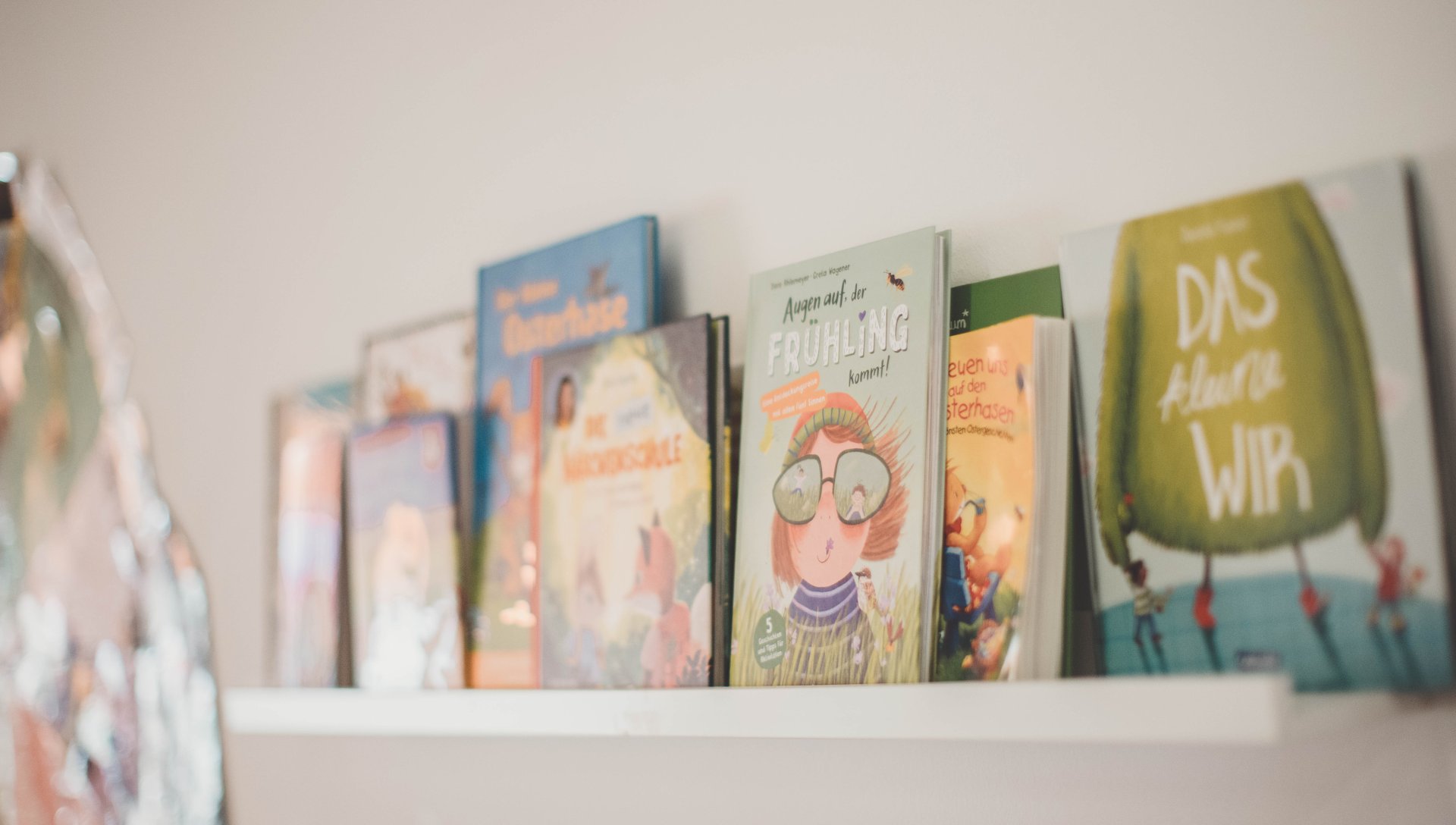 Kita Haus der Klänge Auf einem Regalbrett stehen einige Kinderbücher.