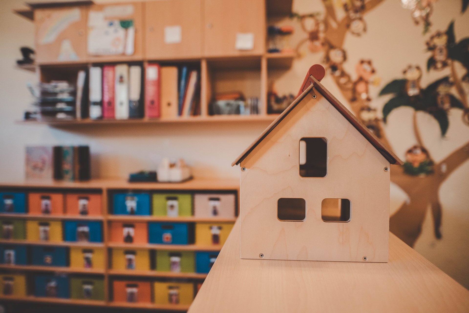Haus aus Holz und im Hintergrund viele Fächer und Ordner