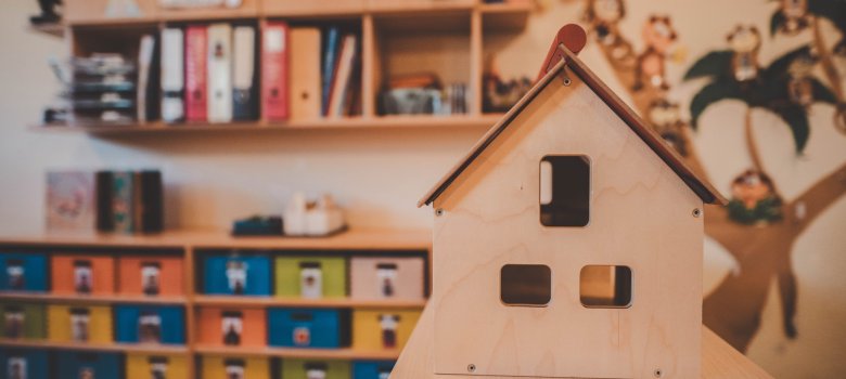 Haus aus Holz und im Hintergrund viele Fächer und Ordner