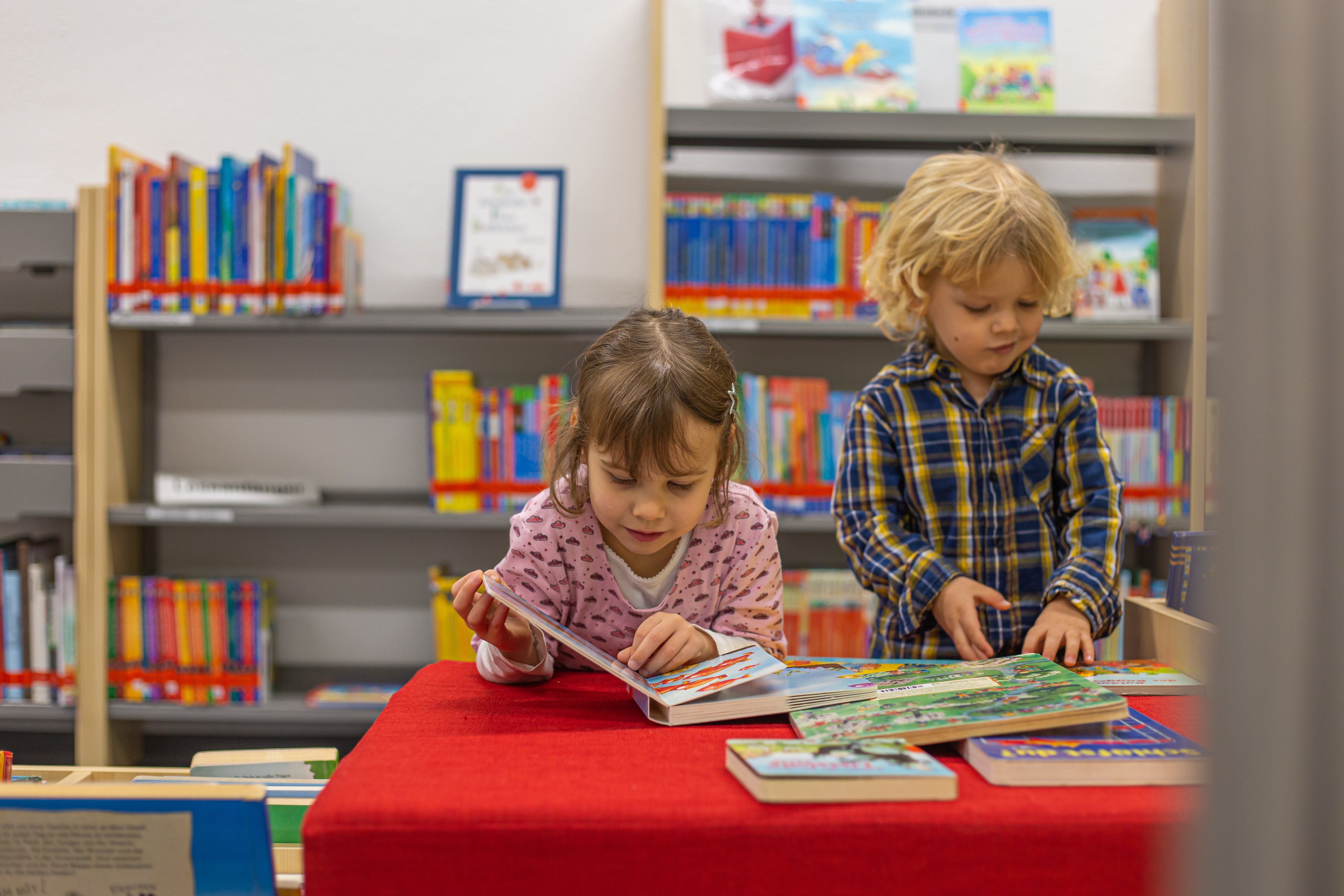 Zwei Kinder lesen gemeinsam in der Bücherei