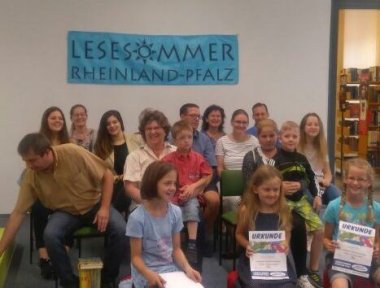 Kinder halten ihre Urkunde für den Lesesommer