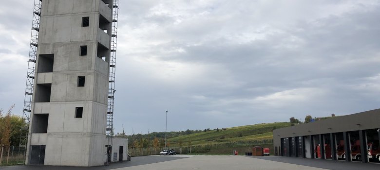 Auf der linken Seite der 25 Meter hohe Ausbildungsturm mit entsprechenden Anleitermöglichkeiten für tragbare Leitern und die Drehleiter. Außerdem verfügt der Turm über eine Steigleitung, einen Kellerbereich und eine "heiße Tür" für die Atemschutzausbildung.
Auf der linken Seite der 25 Meter hohe Ausbildungsturm mit entsprechenden Anleitermöglichkeiten für tragbare Leitern und die Drehleiter. Außerdem verfügt der Turm über eine Steigleitung, einen Kellerbereich und eine "heiße Tür" für die Atemschutzausbildung.