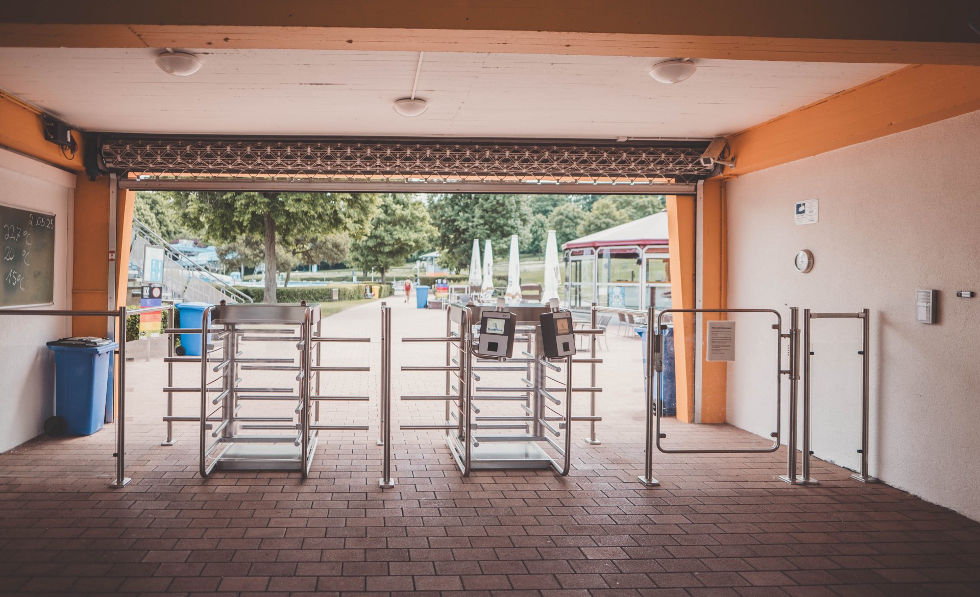 Auf dem Bild sind die Drehtüren im Eingangsbereich des Alzeyer Freibads abgebildet. Im Hintergrund ist der Eingangsbereich des Alzeyer Freibads abgebildet.