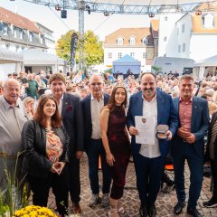 Mehrere Personen stehen nebeneinander und lachen in die Kamera.