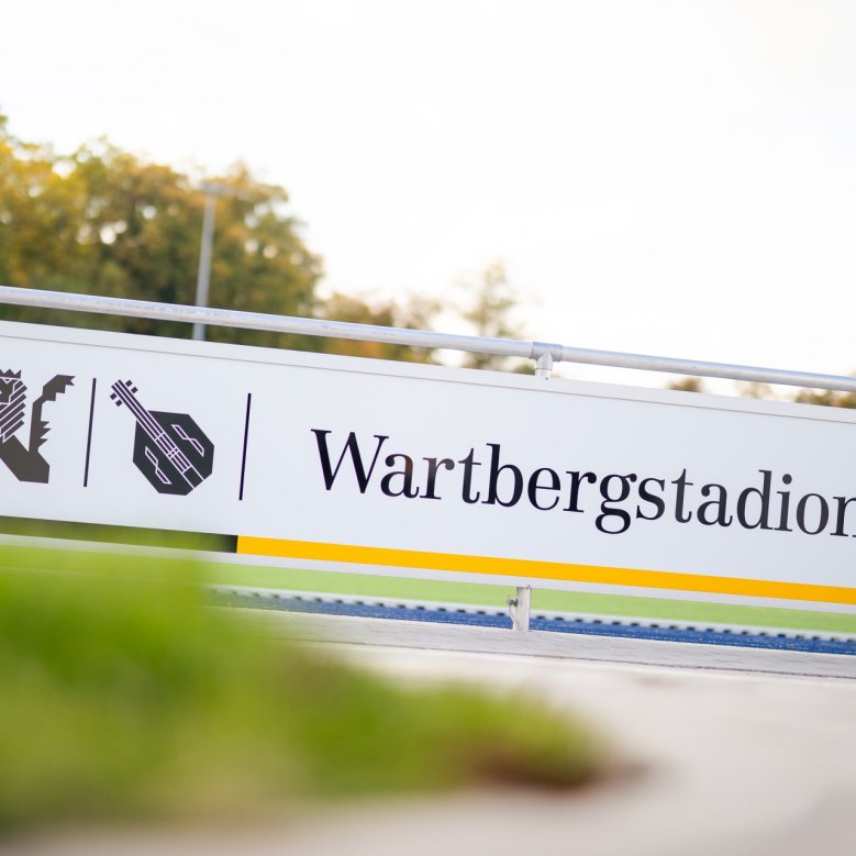 Ein Schild, auf dem das Alzey Wappen steht und anschließend Wartbergstadion Alzey.