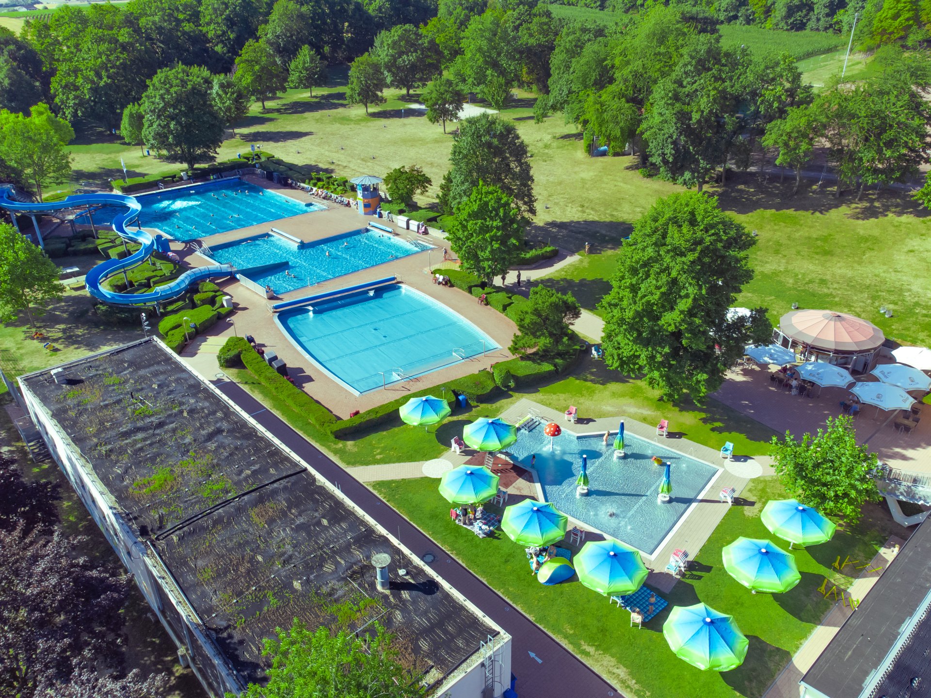 Die Schwimmbecken vom Alzeyer Freibad von oben, mit der freien Wiese.