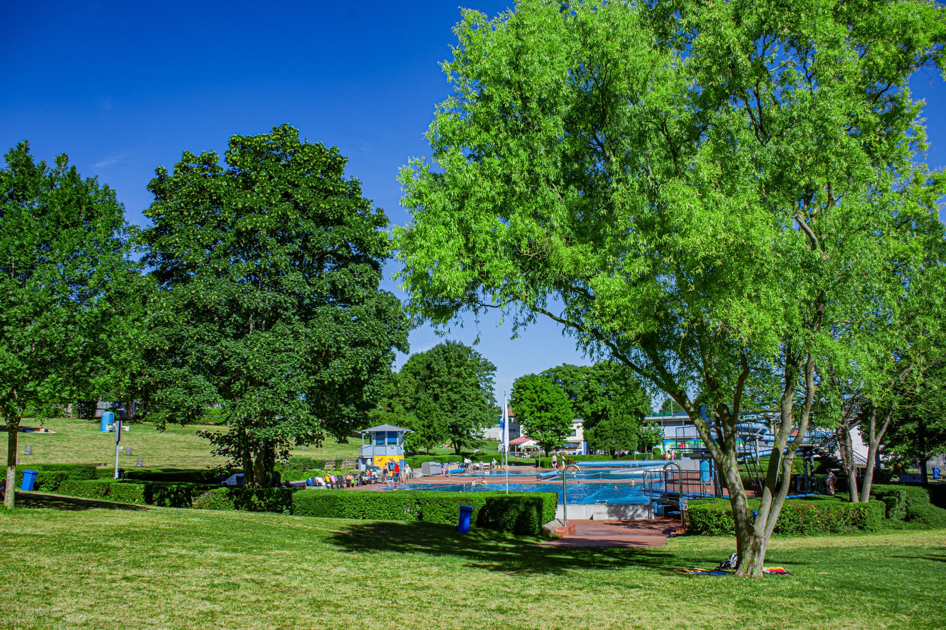 Mit der Sicht von der Wiese, auf das Schwimmerbecken.