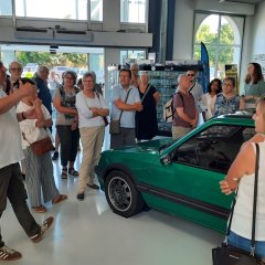 Personen, an grünem Auto.