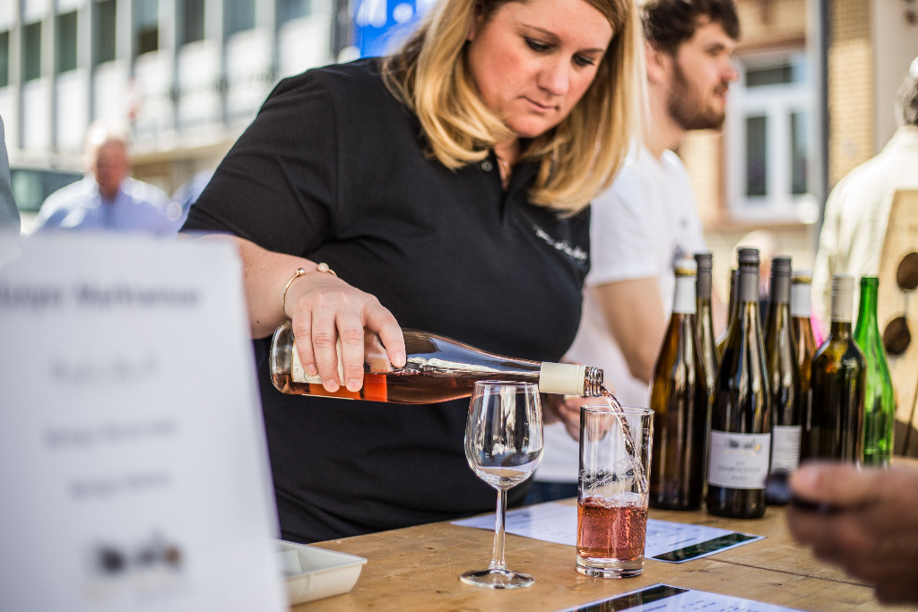 Person schenkt Wein aus