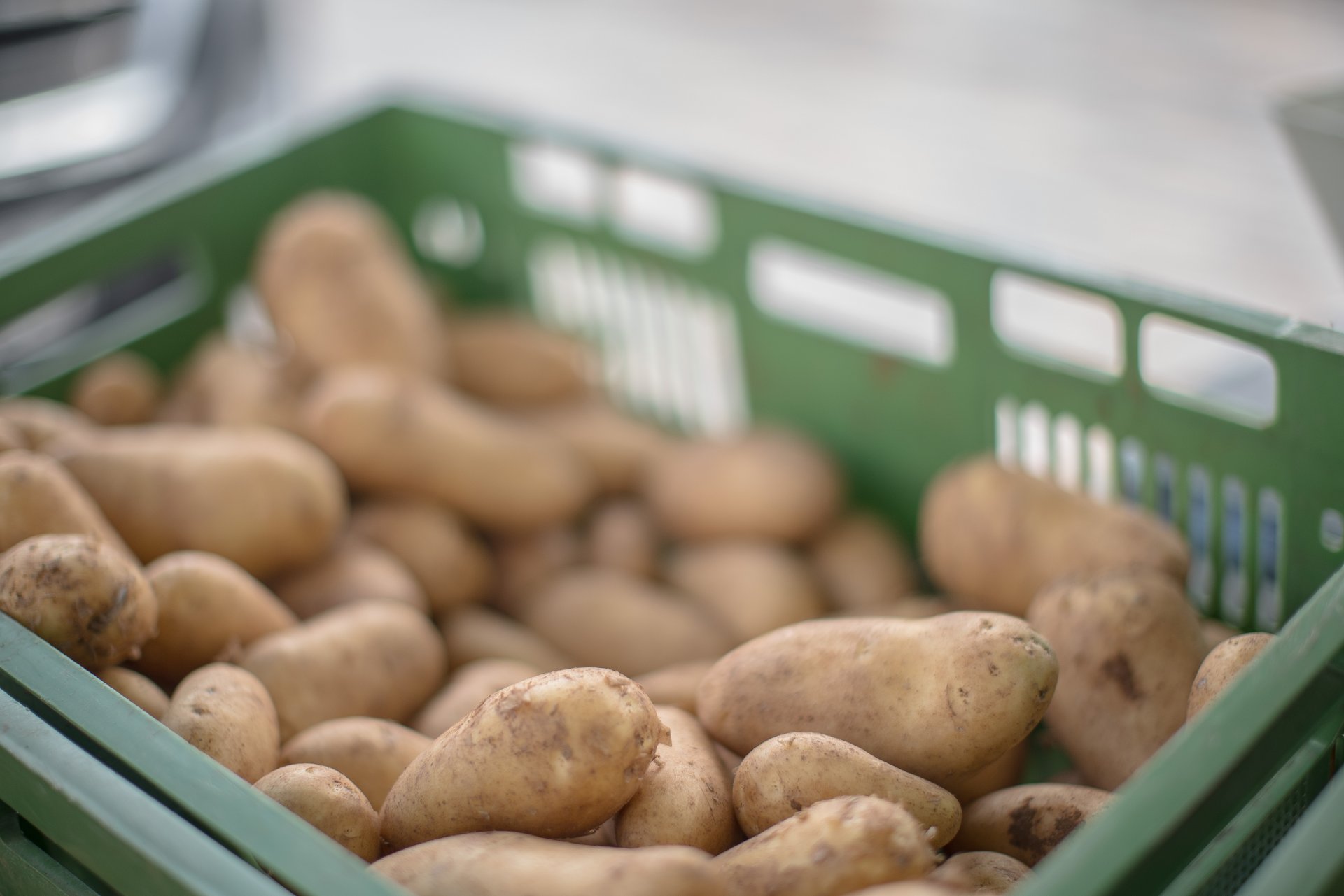 Man sieht eine Verkaufskiste mit Kartoffeln.