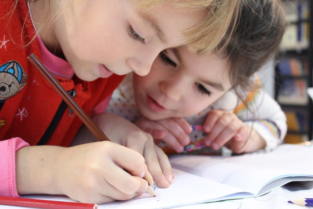 Zwei Kinder schrieben zusammen in ein Heft