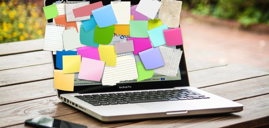 Offener Laptop mit vielen Post-It Aufklbern auf dem Bildschirm