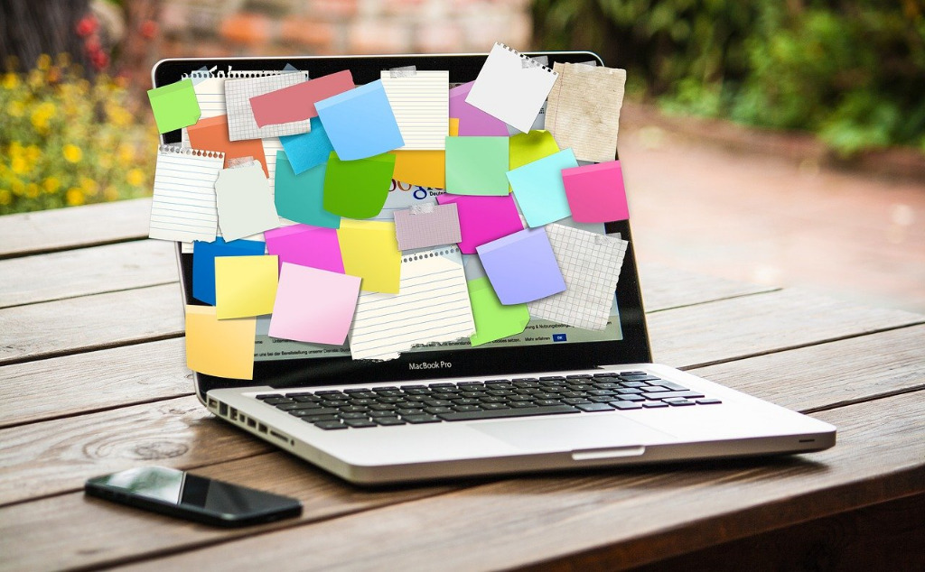 Offener laptop mit vielen Post-It Stickern auf dem Bildschirm