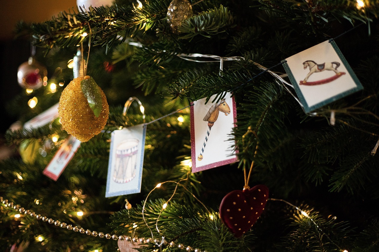 Ein geschmückter Weihnachtsbaum mit figuren und einer Lichterkette und Girlande.