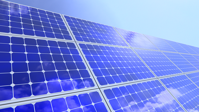 Die Sonne scheint auf viele Solarpaneele.