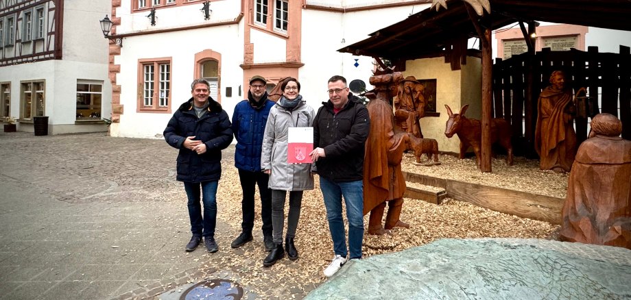 Fünf Personen stehen vor der großen Weihnachtskrippe auf dem Alzeyer Fischmarkt