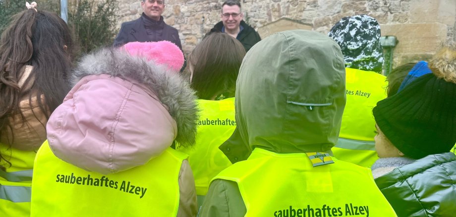 Kinder mit Warnwesten auf denen steht: sauberhaftes Alzey