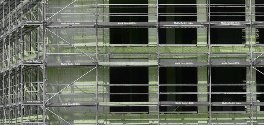 Ein fensterloser Rohbau, der von Gerüst umgeben ist.