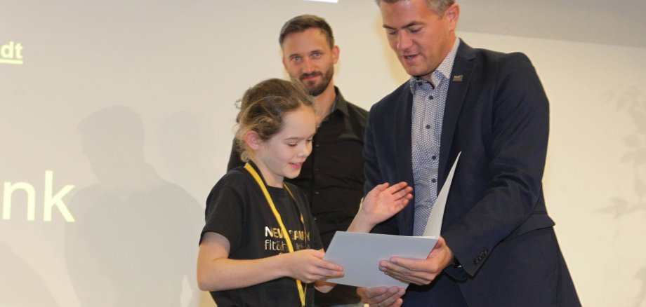 Bürgermeister gib einem jungen Mädchen eine Urkunde