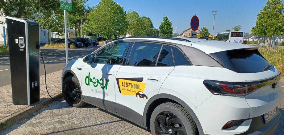 Zu sehen ist ein Auto von deer Carsharing an einer Ladesäule