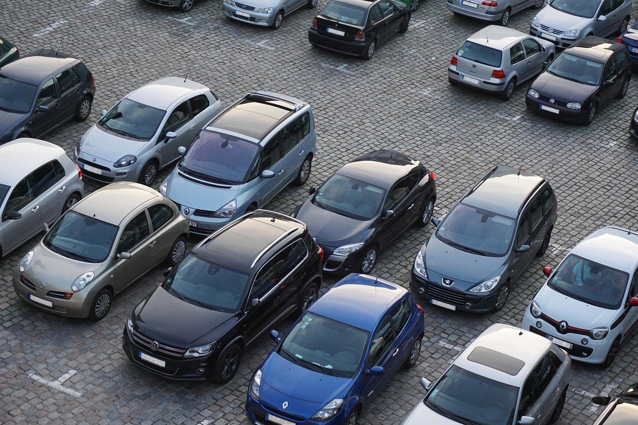 Man sieht einen Parkplatz mit geparkten Autos.