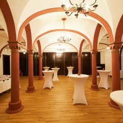 Ein heller Raum in der Stadthalle mit einigen Stehtischen und ein noch nicht vollständig aufgebautes Buffet.
