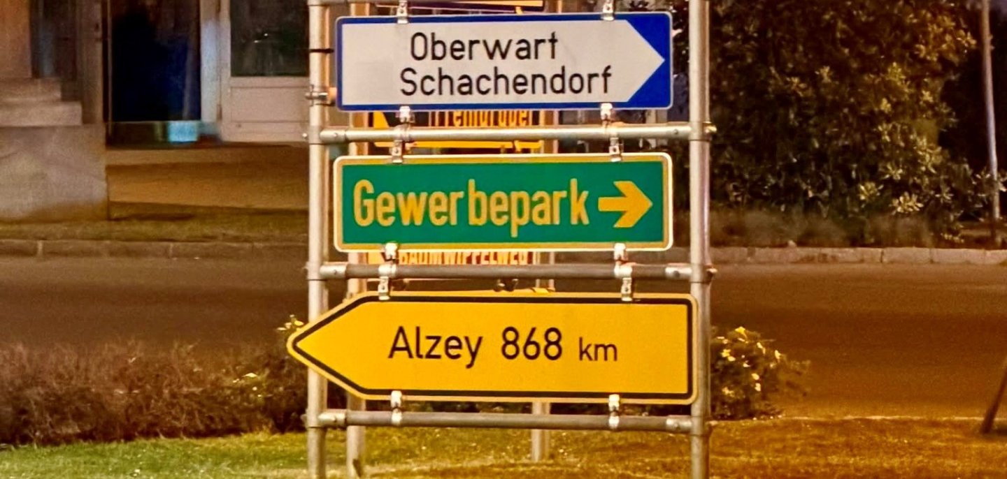 Verkehrsschilder, darunter auch eins mit der Aufschrift: Alzey 868 Kilometer
