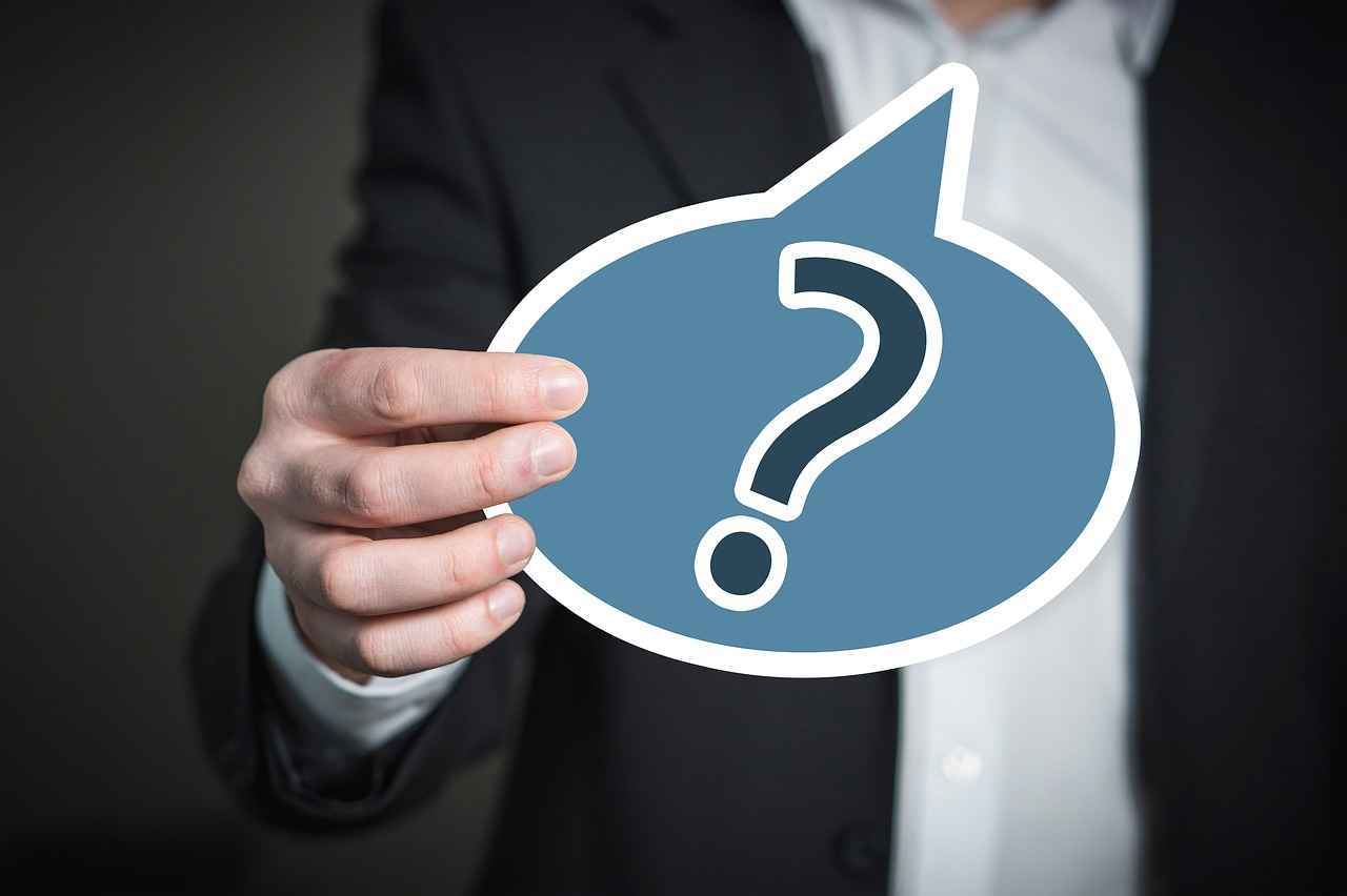 eine blaue Sprechblase mit einem Fragezeichen drin und wird gehalten
