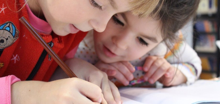 Zwei Kinder schrieben zusammen in ein Heft