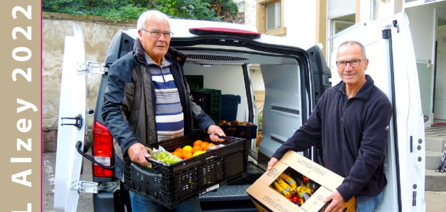 Zwei Personen heben Obst aus dem Auto