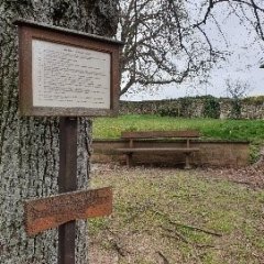 Bank und Schild an der Kirche