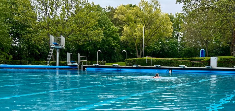 Eine einzelne Person schwimmt in einem Schwimmbecken.