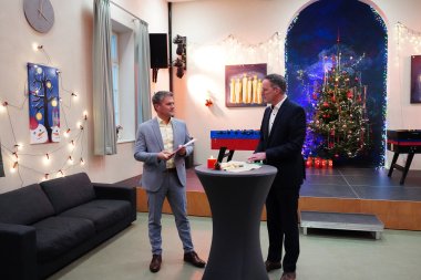 Zwei Personen stehen gemeinsam an einem Stehtisch im JUKU