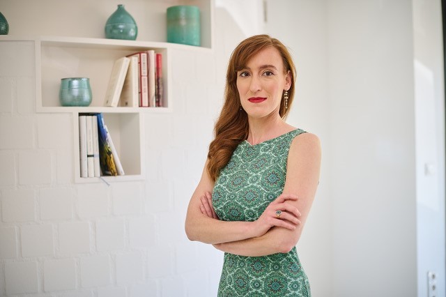 Nora Bossong vor einem Regal mit Vasen und Blumen