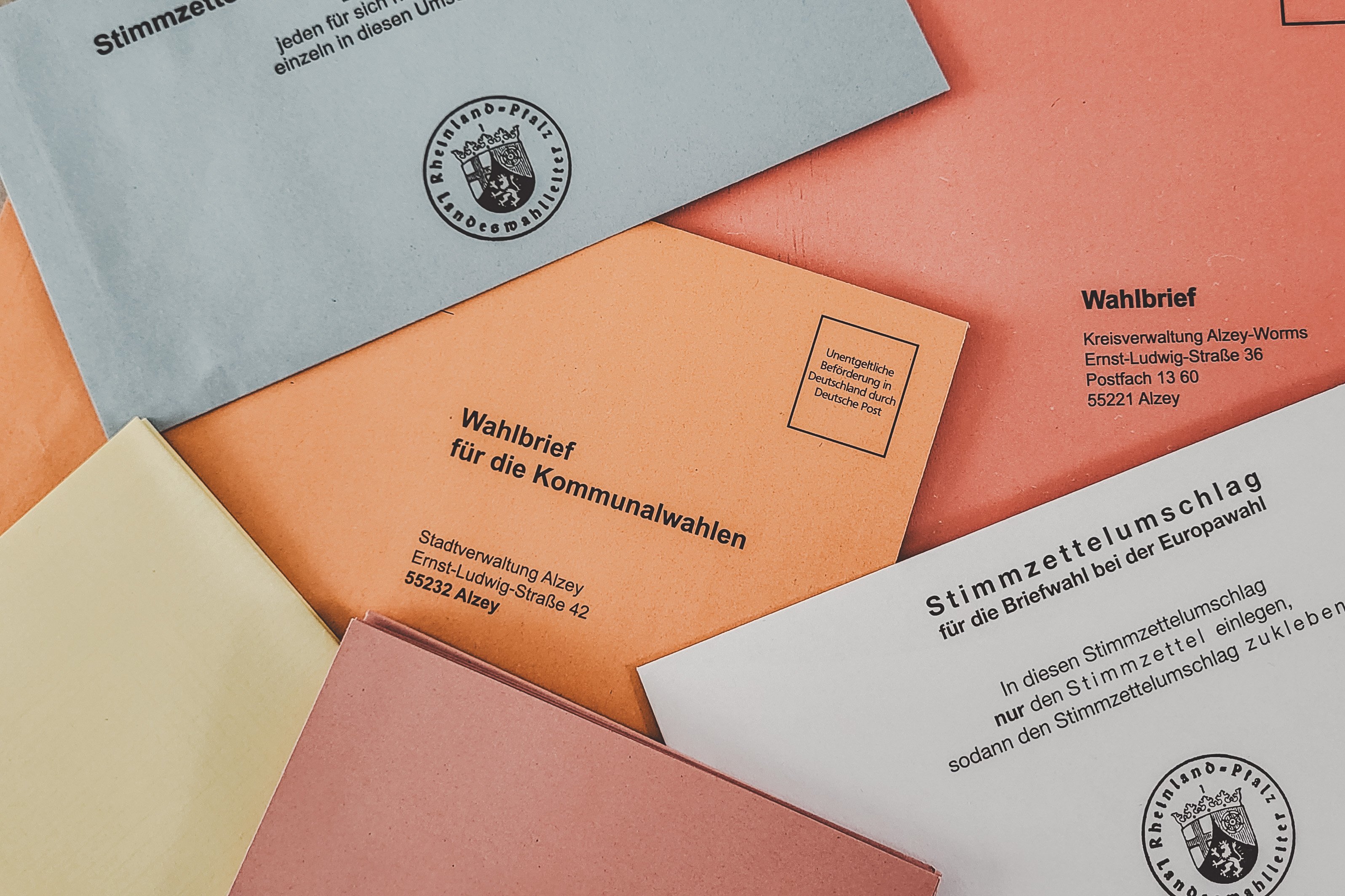 Viele bunte Zettel und Briefumschläge liegen wild übereinander gestapelt.