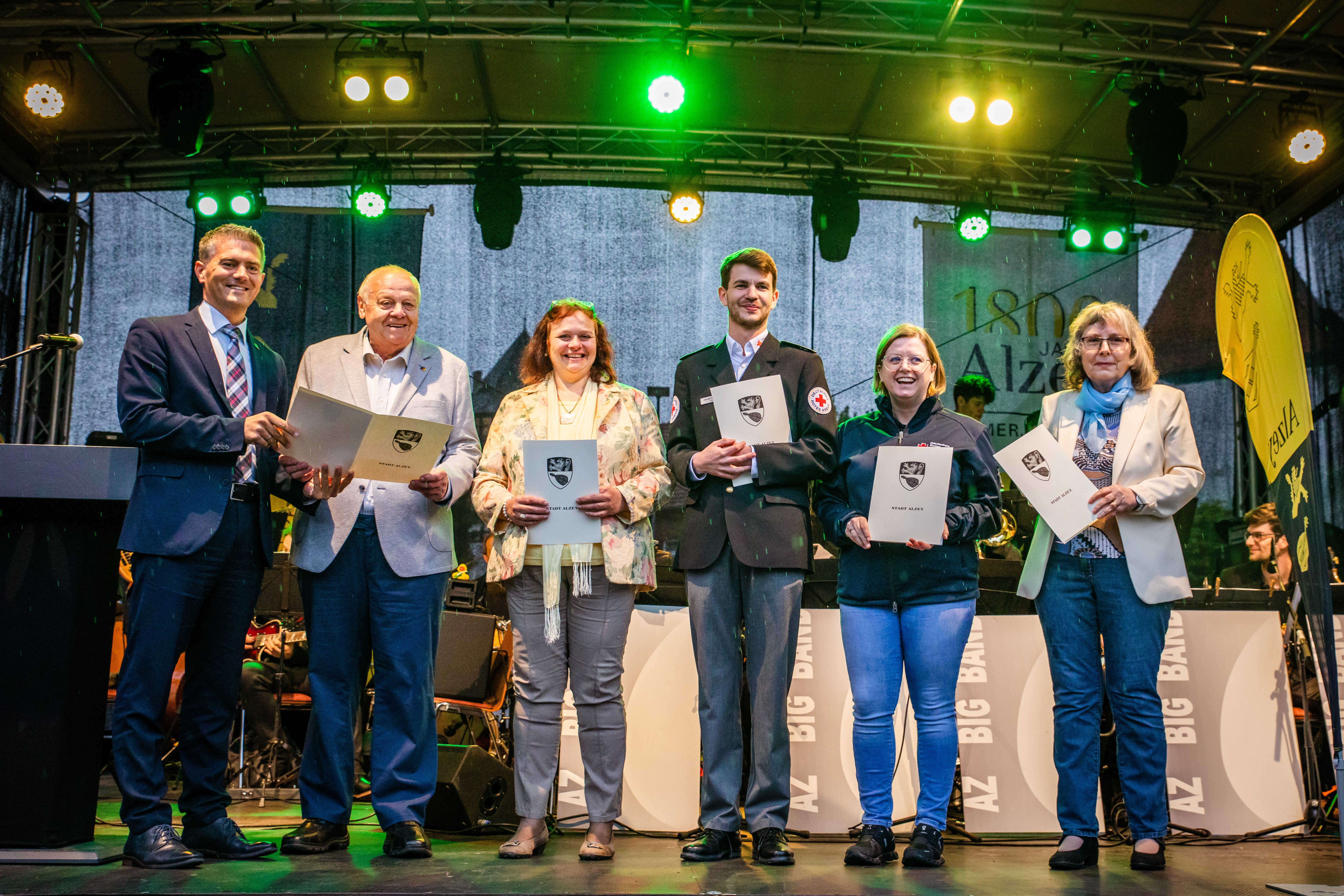 Auf eine Bühne stehen mehrere Personen mit Urkunden.