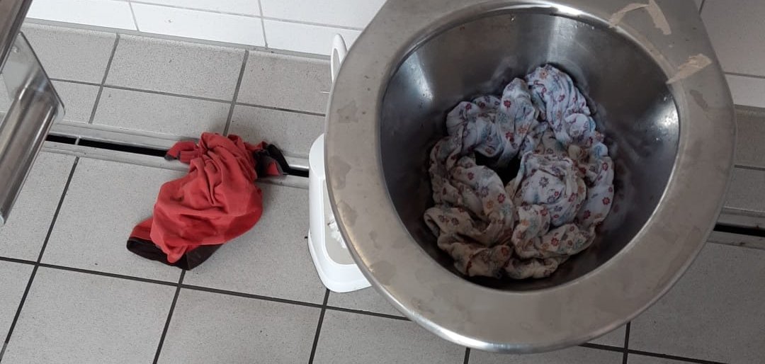 Ein metallener Klositz, in dem verschiedene Stofflappen befinden.