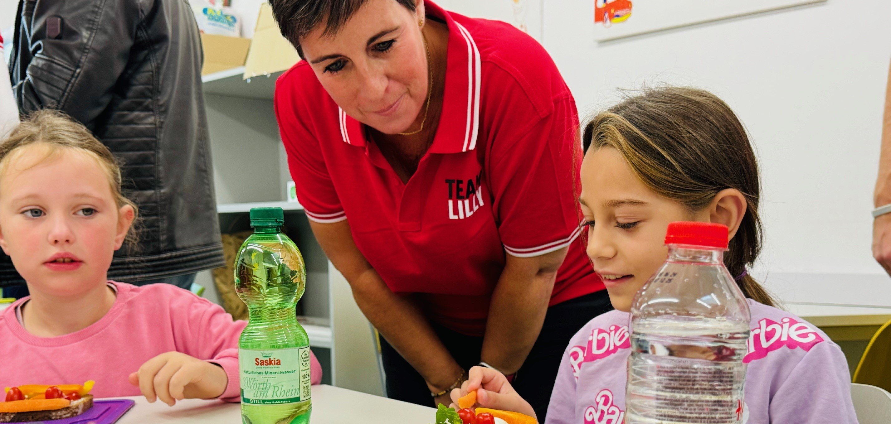 Im Rahmen des Global Day of Service basteln die Kinder der ASS mit Mitarbeitern ihre leckeren Brotgesichter aus Gemüse und Obst.